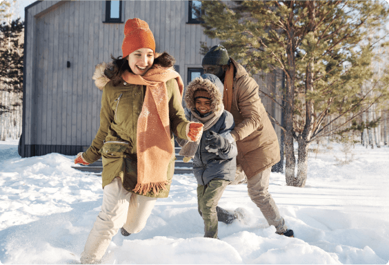 Three family members running around playing in the snow